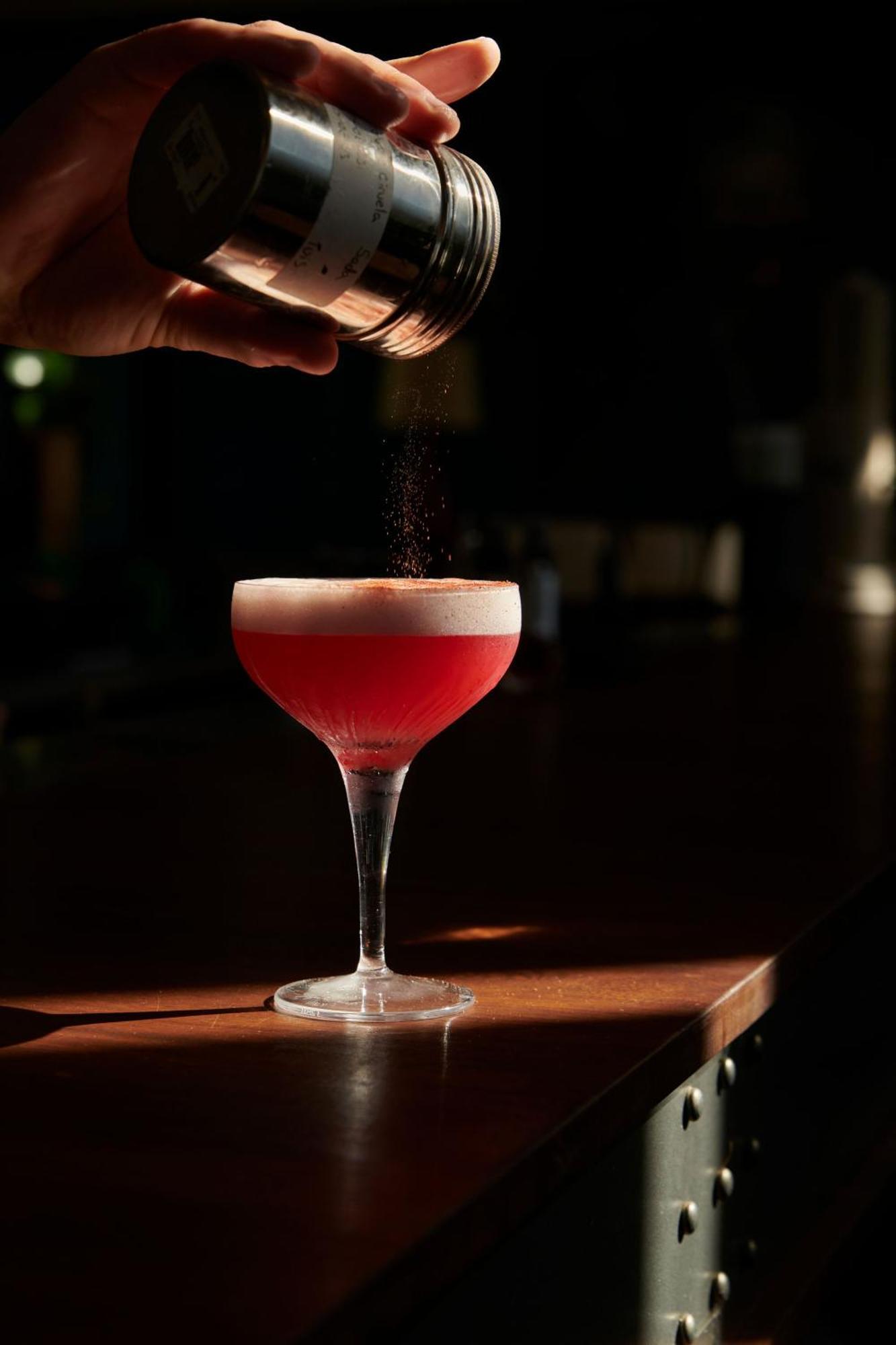 The Click Clack Hotel Medellín Exteriér fotografie A Clover Club cocktail being garnished with ground nutmeg